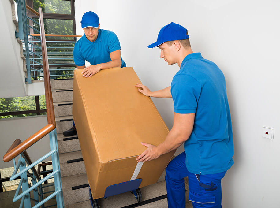 Avatar Umzüge - Möbelpacker tragen schweren Umzugskarton durch Treppenhaus